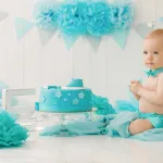 1 year old boy with a cake and decorations for his 1st birthday party