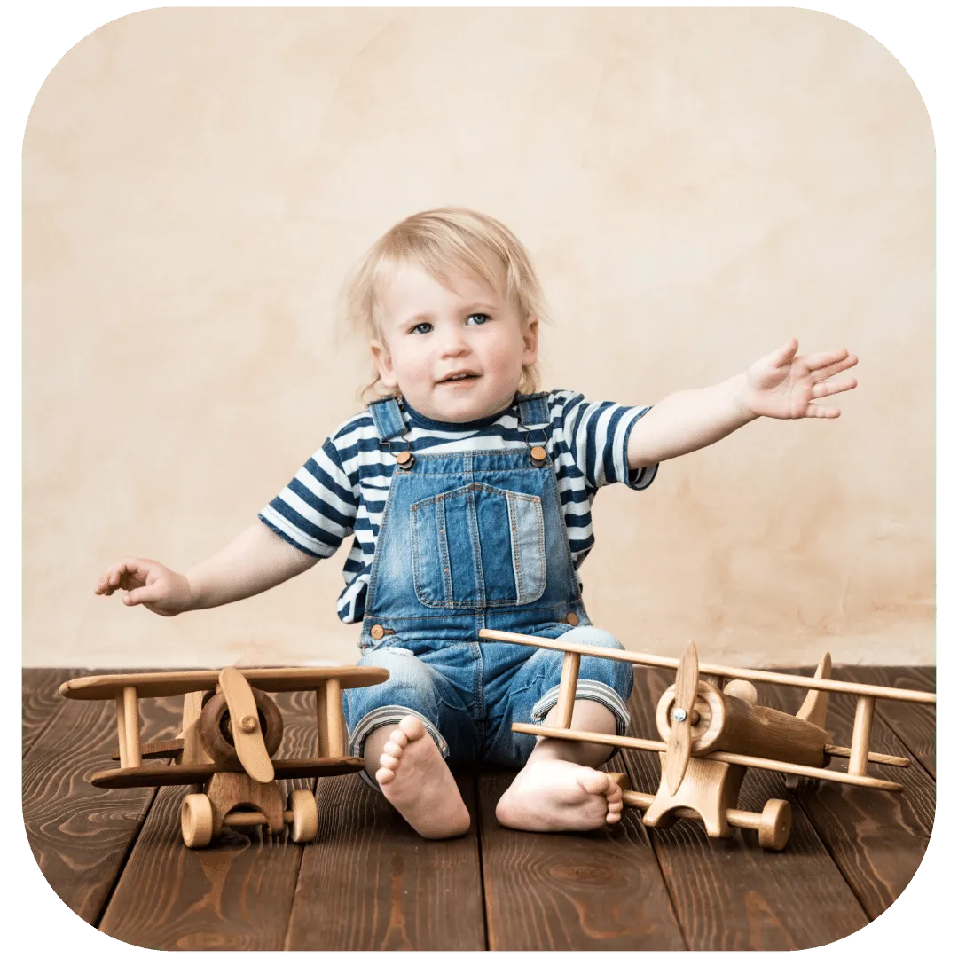 1 year old with 2 wooden airplanes as decorations for a vintage airplane 1st birthday party