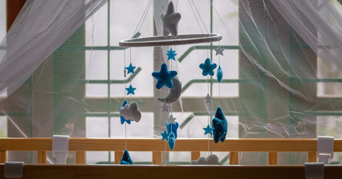 blue and white moon and stars baby mobile hanging over a crib